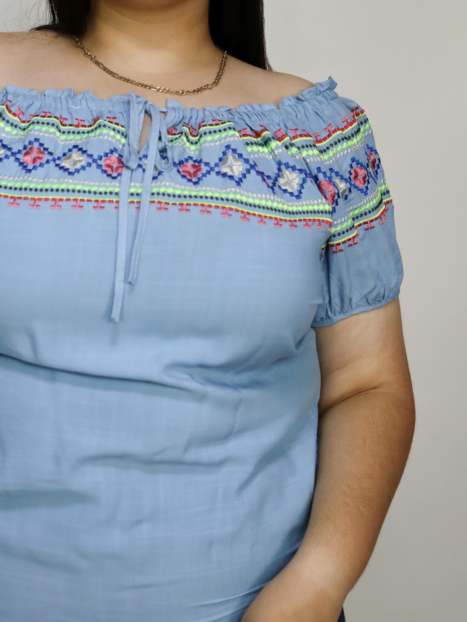 Blusa azul con flores en hombros